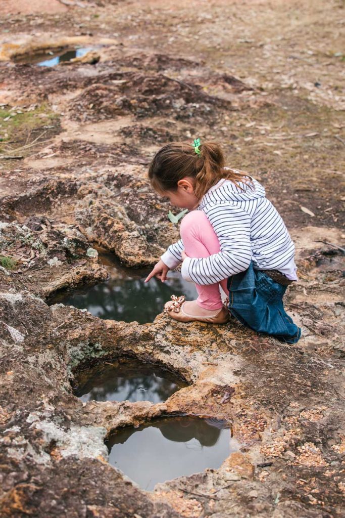 child looking at one of the native rock wells in Yuleba